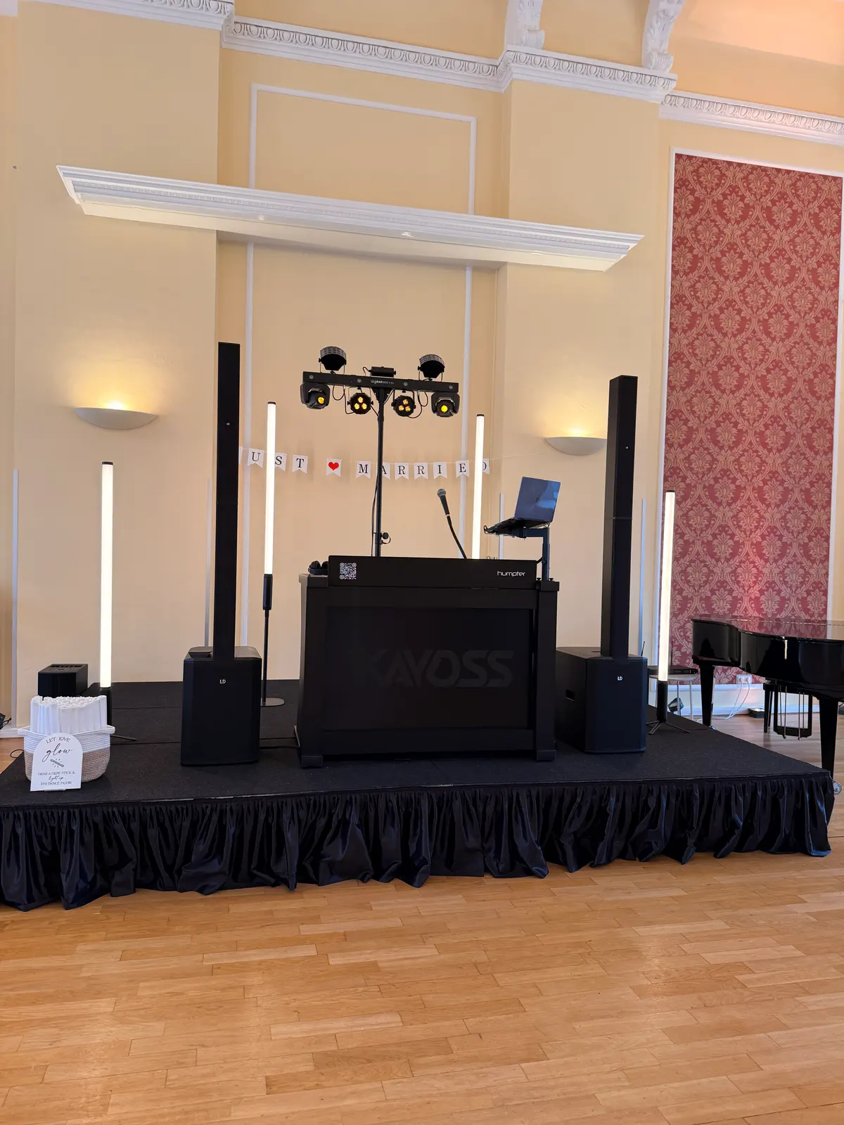 DJ-Pult von DJ Kayoss mit Lautsprechern, Lichttechnik und Leuchtstäben auf einer Bühne im Saal des Hotels am Schloss in Aurich
