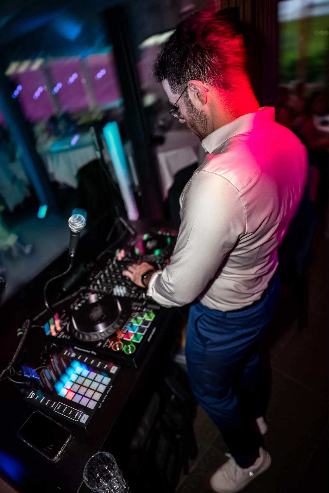 DJ Kai Schmidt am Controller im pinkfarbenen Licht