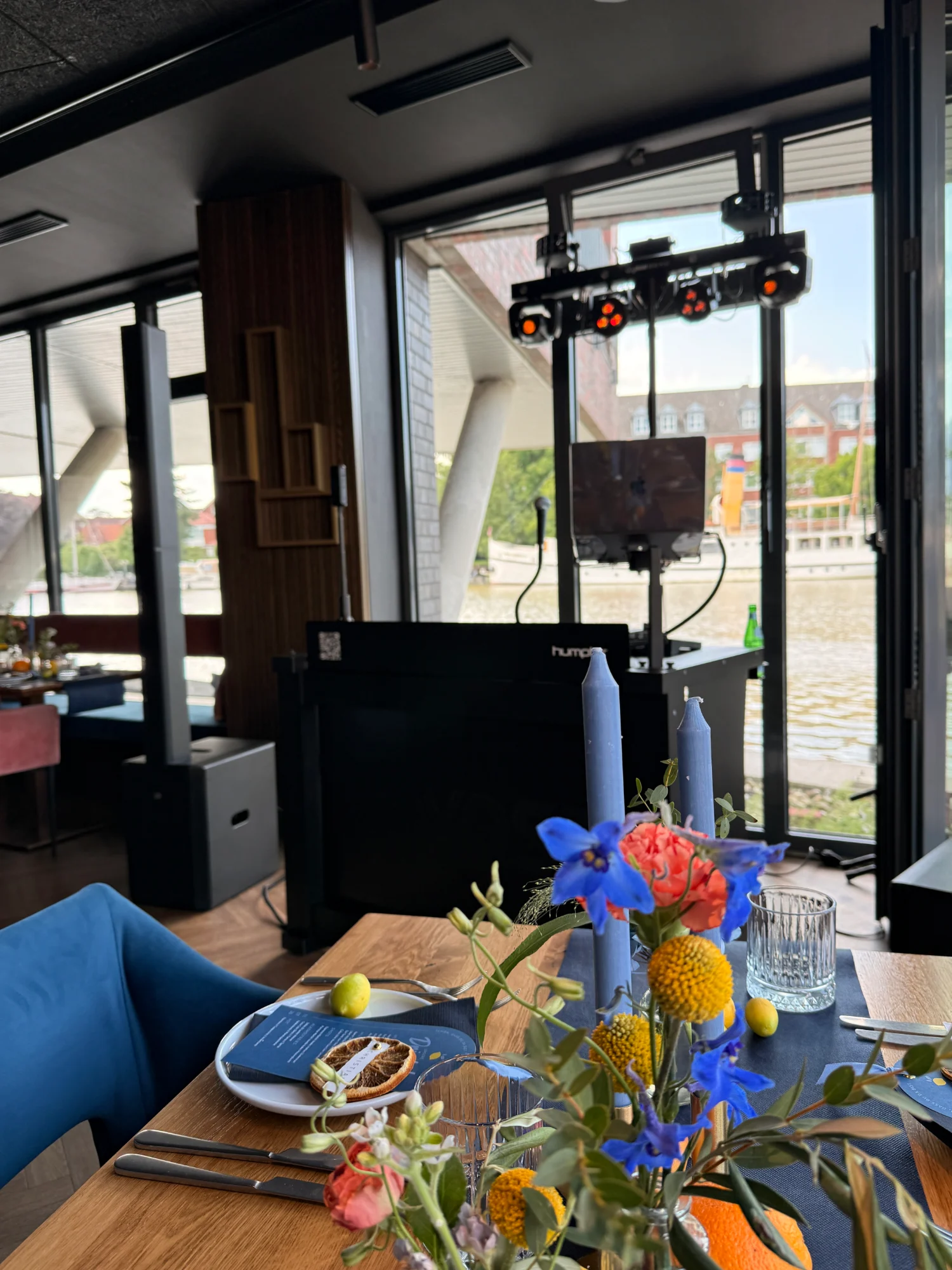 Havnbar in Leer: festlich gedeckte Tafel und DJ-Pult vor der Fensterfront mit Blick auf die Leda
